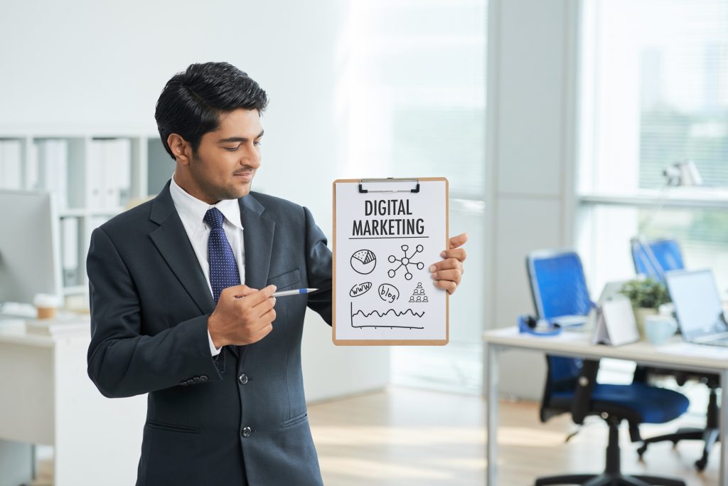 man-suit-standing-office-with-clipboard-pointing-poster-with-words-1-1024x683 Freelancing and Digital Marketing Courses 2023-2024